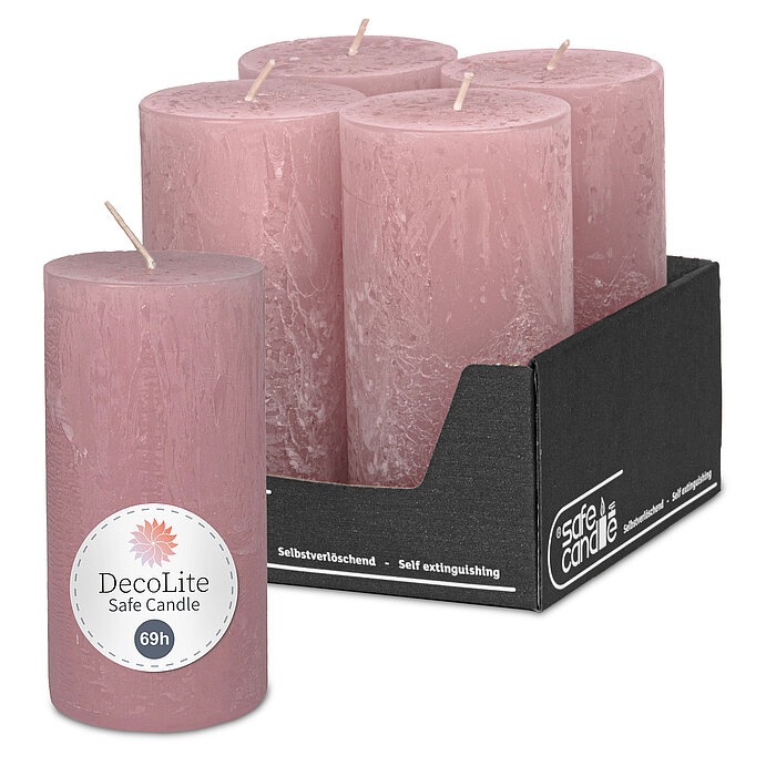 Eine Rustik-Stumpenkerze von Decolite 140/70mm (H/DM) mit Etikett „Safe Candle“ und "69h Brenndauer" in der Farbe Antikrosa. Im Hintergrund ist das komplette 4er Paket der angebotenen Kerzen abgebildet, ein grauer Umkarton mit "Safe Candle" Aufdruck.