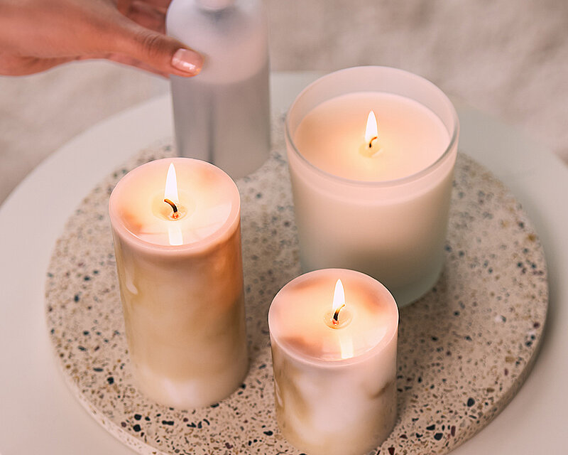 Dekorative Wohnszene mit der Bolsius Marble Kollektion: Marmoreffekt-Stumpenkerzen in zwei Größen, Duftkerze im Glas und Reed Diffuser auf einem modernen Beistelltisch. Stilvolle Kerzendekoration für ein gemütliches und elegantes Zuhause.