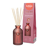 Ein Raumduft-Diffuser mit Rattanstäbchen aus rosa Milchglas mit der Duftrichtung "Floral Blessings". Im Hintergrund ist die Verpackung des Artikels mit Bolsius Schriftzug zu sehen.