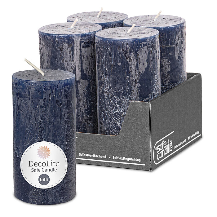 Eine Rustik-Stumpenkerze von Decolite 140/70mm (H/DM) mit Etikett „Safe Candle“ und "69h Brenndauer" in der Farbe Nachtblau. Im Hintergrund ist das komplette 4er Paket der angebotenen Kerzen abgebildet, ein grauer Umkarton mit "Safe Candle" Aufdruck.